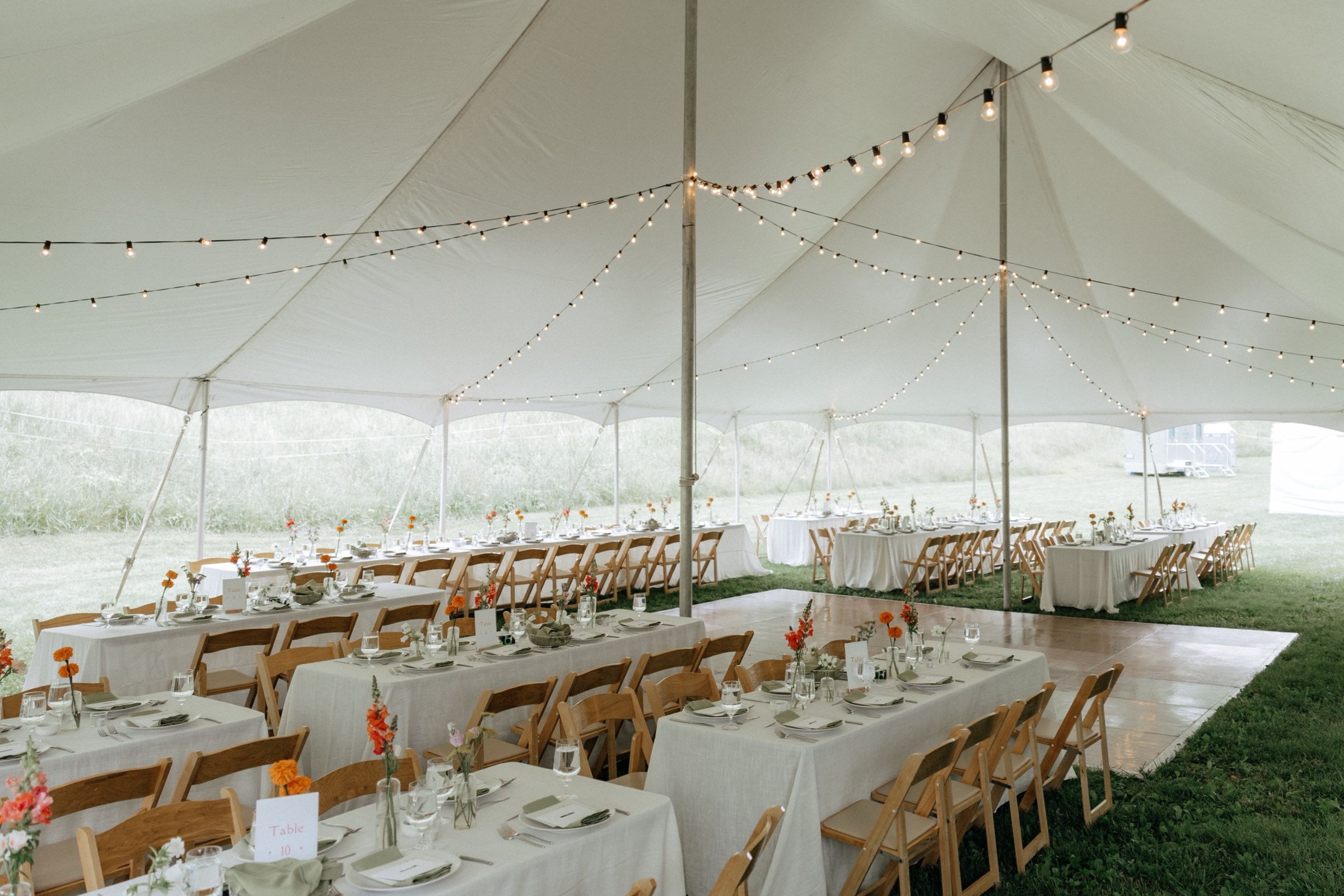 Family-style reception table setting under string lights in Western North Carolina